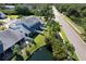 Aerial view of townhomes with screened patios and lush landscaping adjacent to a pond at 284 Hemingway Dr, Oldsmar, FL 34677