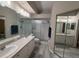 Bright bathroom featuring a dual sink vanity, glass shower enclosure, and ample mirrored closet space at 284 Hemingway Dr, Oldsmar, FL 34677