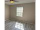 Neutrally decorated bedroom with bright window offering natural light and gray wood-look floors at 284 Hemingway Dr, Oldsmar, FL 34677