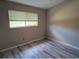 Bedroom featuring a window with blinds illuminating the gray laminate flooring at 284 Hemingway Dr, Oldsmar, FL 34677