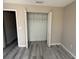 Bedroom featuring a spacious closet with bi-fold doors and laminate wood flooring at 284 Hemingway Dr, Oldsmar, FL 34677