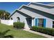 Charming home featuring well-manicured landscaping, bright blue shutters, and a welcoming front porch at 284 Hemingway Dr, Oldsmar, FL 34677