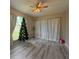 Bright living room featuring gray wood-look floors, ceiling fan, and large window at 284 Hemingway Dr, Oldsmar, FL 34677