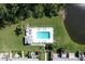 Aerial view of a community pool with lounge chairs, tables, and a gazebo near a pond at 284 Hemingway Dr, Oldsmar, FL 34677