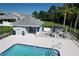 Close aerial view of a community pool and adjacent clubhouse-like structure with tables, chairs, and umbrellas at 284 Hemingway Dr, Oldsmar, FL 34677