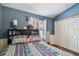 Blue bedroom featuring wood-look floors, a ceiling fan, and a large window at 3406 Cypress Head Ct, Tampa, FL 33618