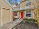 Charming home's front entrance featuring a vibrant red door and meticulously maintained landscaping at 3406 Cypress Head Ct, Tampa, FL 33618