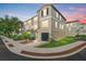 Inviting multi-story townhome with an attached garage, manicured lawn and colorful sunset backdrop at 4405 Tuscan Loon Dr, Tampa, FL 33619