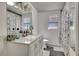 Clean, white bathroom with updated vanity, lighting, and matching marble shower curtain at 4716 Gazania St, New Port Richey, FL 34652