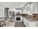 Bright kitchen with white cabinetry, brick backsplash, and stainless steel appliances at 4716 Gazania St, New Port Richey, FL 34652