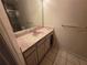 Bathroom vanity features a pink countertop, mirrored wall, and tile flooring at 5024 Sunridge Palms Dr # 101, Tampa, FL 33617