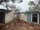 Exterior of a weathered home, showing its potential for renovation and restoration, set in an overgrown yard at 5218 Winding Way, Sarasota, FL 34242