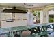Community outdoor grill area with a large grill, picnic tables, and a ceiling fan at 5971 Terrace Park N Dr # 310, St Petersburg, FL 33709
