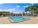 Exterior view of the community pool area featuring chairs, tables, and clear, inviting water at 5971 Terrace Park N Dr # 310, St Petersburg, FL 33709