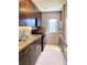 Galley kitchen featuring wood cabinets, modern appliances, and access to outdoor space at 5971 Terrace Park N Dr # 310, St Petersburg, FL 33709