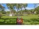Picturesque pond view accessible via red wooden bridge, surrounded by lush landscaping and mature trees at 5971 Terrace Park N Dr # 310, St Petersburg, FL 33709
