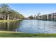 Scenic pond view of condos with lush trees and tranquil waters under a clear sky at 5971 Terrace Park N Dr # 310, St Petersburg, FL 33709