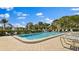 Community swimming pool with lounge chairs, umbrellas, and lush landscaping, offering a resort-like experience at 5971 Terrace Park N Dr # 310, St Petersburg, FL 33709