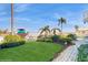 Manicured backyard with palm trees, flowering plants, green grass and a boat in the canal at 750 123Rd Ave, Treasure Island, FL 33706