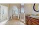 An elegant primary bathroom showcasing a soaking tub, walk-in shower, and vanity with granite countertop at 750 123Rd Ave, Treasure Island, FL 33706