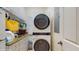 Laundry area with white cabinets, stone countertops, sink, and a stacked washer and dryer at 750 123Rd Ave, Treasure Island, FL 33706