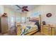 Relaxing bedroom with a ceiling fan, a decorative turtle theme, and shuttered windows at 750 123Rd Ave, Treasure Island, FL 33706