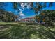 Lush backyard featuring a screened-in patio, mature trees, and well-maintained lawn at 7888 Lantana Creek Rd, Largo, FL 33777