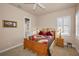 Comfortable bedroom with a wooden bed frame, colorful quilt, and a window with plantation shutters at 7888 Lantana Creek Rd, Largo, FL 33777