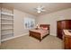 Cozy bedroom featuring a ceiling fan, a window with plantation shutters, a bed, and a dresser at 7888 Lantana Creek Rd, Seminole, FL 33777