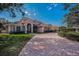 Beautiful house with a paved driveway, landscaped lawn, and a red tile roof on a sunny day at 7888 Lantana Creek Rd, Seminole, FL 33777