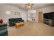 Open living room featuring a ceiling fan, stairs to the second floor, modern lighting, and a comfortable green sofa at 7888 Lantana Creek Rd, Seminole, FL 33777