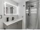 Updated bathroom features a sleek vanity with a backlit mirror and walk-in shower with mosaic tile floor at 7990 42Nd N St, Pinellas Park, FL 33781