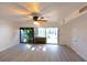 Sunny bonus room offers access to the pool area through sliding glass doors with a ceiling fan at 7990 42Nd N St, Pinellas Park, FL 33781
