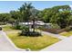 A modern home with a flat roof, a red door, a circular driveway, and mature palm trees at 7990 42Nd N St, Pinellas Park, FL 33781