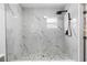 Sleek walk-in shower showcasing large, white marble-patterned tiles and a stylish rain shower head at 7990 42Nd N St, Pinellas Park, FL 33781