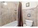 Full bathroom with tiled walls, shower with curtain, and updated toilet at 8517 43Rd W Ave, Bradenton, FL 34209