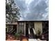 Condo exterior with tan paint, stone details, dark wood stairs, and mature trees at 8550 Shadblow Ct # 2, Port Richey, FL 34668