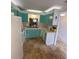 Charming kitchen with turquoise cabinetry, laminate countertops, and tile flooring at 8550 Shadblow Ct # 2, Port Richey, FL 34668