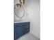 Chic powder room with stylish vanity, modern mirror, updated fixtures, and elegant herringbone flooring at 870 N Osceola Ave, Clearwater, FL 33755
