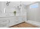 Bright bathroom features double vanity, modern lighting, and a glass shower with a window at 870 N Osceola Ave, Clearwater, FL 33755