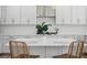 A close-up of the kitchen island with seating and white countertops, perfect for casual dining and conversation at 870 N Osceola Ave, Clearwater, FL 33755