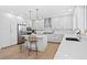 Bright, modern kitchen featuring white cabinetry, stainless appliances, white countertops and island with seating at 870 N Osceola Ave, Clearwater, FL 33755