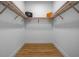 Walk-in closet featuring wooden shelving, laminate floors, and white baseboards at 870 N Osceola Ave, Clearwater, FL 33755