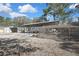 View of metal barn, RV under metal carport, and dog kennel on gravel lot with trees at 9019 Long Lake Ave, Weeki Wachee, FL 34613