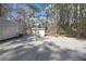 View of shed and trailer on gravel lot surrounded by pine trees and other foliage at 9019 Long Lake Ave, Weeki Wachee, FL 34613