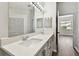 Bright bathroom featuring a double sink vanity with modern fixtures and an expansive mirror at 915 Brittany Park Blvd, Tarpon Springs, FL 34689