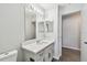 This bathroom features a large mirror, double sink vanity, toilet and white cabinets at 915 Brittany Park Blvd, Tarpon Springs, FL 34689