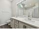 Bright bathroom featuring a double vanity and an enclosed shower and tub at 915 Brittany Park Blvd, Tarpon Springs, FL 34689