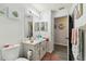 Bright bathroom with a single sink vanity, framed mirror, and decorative art at 915 Brittany Park Blvd, Tarpon Springs, FL 34689