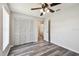 Cozy bedroom with wood floors, closet with louvered doors, ceiling fan, and neutral walls at 915 Brittany Park Blvd, Tarpon Springs, FL 34689